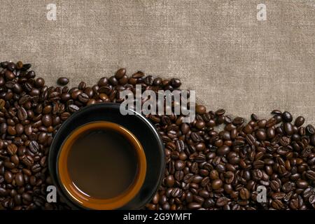 Caffè in grani e tazza di caffè su fondo a scappone Foto Stock