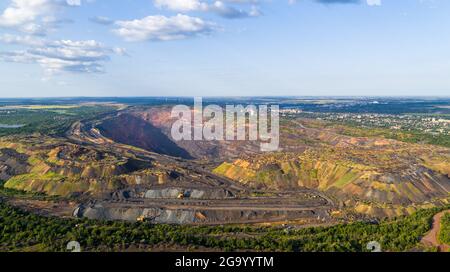 Le macchine e i dumper sono in funzione nella vista aerea della miniera di cava Foto Stock