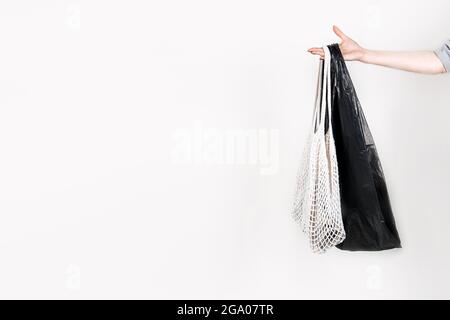Canvas cotone shopping eco-friendly borsa vs plastica shopping borsa in mano femminile su sfondo bianco. Zero sprechi, senza plastica, nessun concetto di plastica Foto Stock