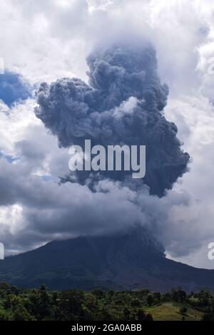 (210728) -- SUMATRA DEL NORD, 28 luglio 2021 (Xinhua) -- Foto scattata il 28 luglio 2021 mostra il Monte Sinabung che sputa materiali vulcanici e fumo come visto da Tiga Pancur a Karo, Sumatra del Nord, Indonesia. (Foto di Sarianto Sembiring/Xinhua) Foto Stock