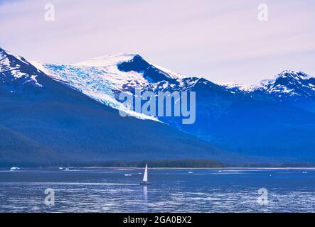 una barca a vela sul lago. Montagne con neve che si scioglie sullo sfondo. I fiordi dell'Alaska, paesaggi naturali unici. Alaska, Stati Uniti. Giugno 2019. Foto Stock