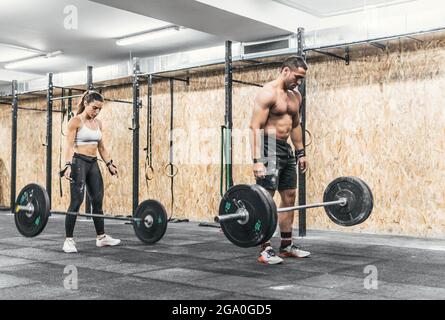 coppia di uomo e donna che fanno pesi in palestra, crossfit Foto Stock