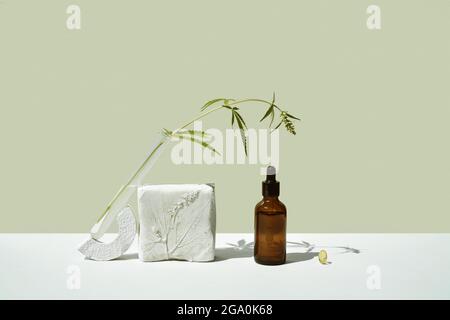 Olio CBD in bottiglia marrone con contagocce e cannabis, branca di canapa Foto Stock