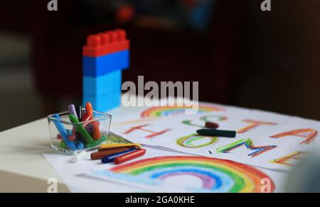 Un ragazzo di 4-7 anni si siede al tavolo e disegna con vernici multicolore. Creatività dei bambini. Hobby per bambini. Foto di alta qualità Foto Stock