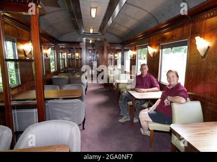 Simon e Diana Parums all'interno del loro treno a vapore di dimensioni complete con carrozze, piste e piattaforma, mentre convertirono e restaurarono la stazione del lago Bassenthwaite a Keswick, offrendo un'esperienza culinaria su una carrozza ristorante di Hollywood come il suo pezzo forte, quando la aprono al pubblico come attrazione. Data immagine: Mercoledì 28 luglio 2021. Foto Stock