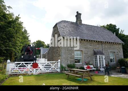 Simon e Diana Parums con il loro treno a vapore di dimensioni complete con carrozze, piste e piattaforma, mentre convertirono e restaurarono la stazione del lago Bassenthwaite a Keswick, offrendo un'esperienza culinaria su una carrozza ristorante di Hollywood come il suo pezzo forte, quando la aprono al pubblico come attrazione. Data immagine: Mercoledì 28 luglio 2021. Foto Stock