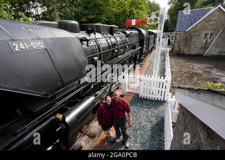 Simon e Diana Parums con il loro treno a vapore di dimensioni complete con carrozze, piste e piattaforma, mentre convertirono e restaurarono la stazione del lago Bassenthwaite a Keswick, offrendo un'esperienza culinaria su una carrozza ristorante di Hollywood come il suo pezzo forte, quando la aprono al pubblico come attrazione. Data immagine: Mercoledì 28 luglio 2021. Foto Stock