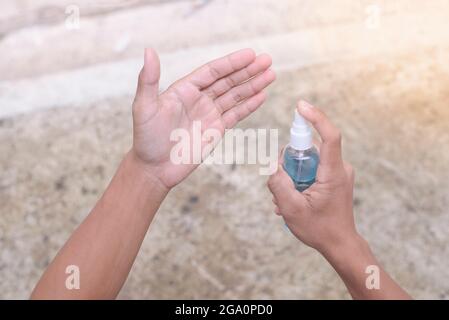 Mano maschile con spray Lavare le mani per uccidere il virus e prevenire l'infezione. Foto Stock