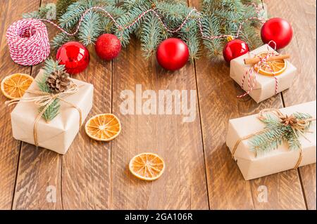 Allegro cornice di Natale con vero legno di pino verde, baubles colorati e altre cose di stagione su un vecchio legno sfondo invecchiato. Foto Stock