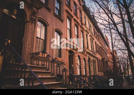 Fila di vecchi edifici di arenaria lungo un marciapiede vuoto blocco nel Greenwich Village quartiere di Manhattan, New York New York Foto Stock