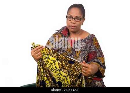 donna matura lava i vestiti a casa in una terrina, piega i bordi del palo prima di calpestarlo nella ciotola Foto Stock