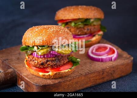 Due hamburger fatti in casa a base di piante a base di patate dolci, fagioli neri e riso bruno su un panino integrale brioche; spazio copia Foto Stock