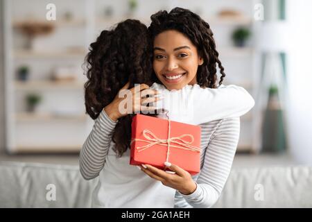 Ragazza nera riccia che saluta la sua mamma con compleanno Foto Stock