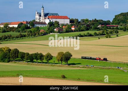 Treno storico della ferrovia del patrimonio Härtsfeld sotto l'abbazia di Neresheim (monastero benedettino), Härtsfeld, distretto di Ostalb, Baden-Württemberg, Germania Foto Stock