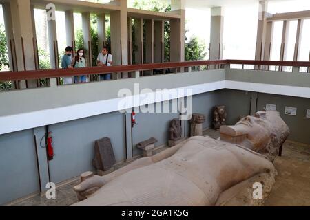 (210728) -- CAIRO, 28 luglio 2021 (Xinhua) -- i turisti guardano alla statua colossale di menzogne dell'antico faraone egiziano Ramesses II alle rovine dell'antica città egiziana di Memphis, circa 23 chilometri a sud-ovest del Cairo, capitale dell'Egitto, 28 luglio 2021. Memphis, fondata intorno al 3,100 a.C., fu la capitale dell'antico Egitto durante il Vecchio Regno che si estende dal 2700-2200 a.C. e rimase una città importante per tutta la storia dell'antico Egitto. Oggi, le rovine dell'ex capitale offrono prove frammentarie del suo passato. Insieme alla sua necropoli (i campi piramidali da Giza a Dahshur), Memphis era io Foto Stock