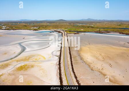 Vista aerea dal drone della strada rialzata di Benbecula che collega le isole di Benbecula (in alto) a sud Uist nelle Ebridi esterne, Scozia, Regno Unito Foto Stock