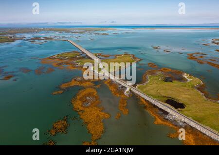 Vista aerea dal drone delle strade di Benbecula che attraversano gli estuari e si uniscono piccole isole attraverso Benbecula nelle Ebridi esterne, Scozia, Regno Unito Foto Stock