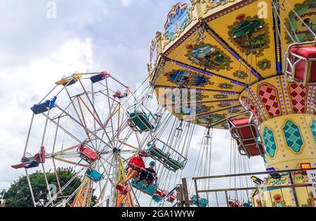 SKEGNESS, LINCOLNSHIRE, REGNO UNITO. 28 luglio 2021. Regno Unito tempo, economia, affari. Mentre l'abolizione delle misure di sicurezza covide continua, le città costiere del Regno Unito si stanno rivelando una destinazione molto popolare per le vacanze estive, insieme con il recente bel tempo caldo e soleggiato, le folle si stanno affolgendo verso il mare. PIC mostra Jude e Oscar Wilkinson godendosi un giro bracing sul giro della fiera delle sedie volanti al divertimento sul mare di Skegness. Credit: phil wilkinson/Alamy Live News Foto Stock