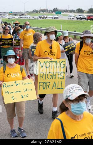 Georgetown, Texas, Stati Uniti. 28 luglio 2021. I sostenitori dei diritti di voto iniziano una marcia di 30 miglia, quattro giorni, da Georgetown, Texas, al Campidoglio di Stato ad Austin. A causa del caldo estivo del Texas, diversi turni da 100 persone si scambieranno di marcia per circa 4 miglia ciascuno. (Immagine di credito: © Bob Daemmrich/ZUMA Press Wire) Foto Stock