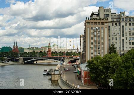 Vista di Mosca verso il Cremlino e il Big Stone Bridge attraverso il fiume Moskva durante il giorno d'estate con il cielo blu e le nuvole bianche. Foto Stock