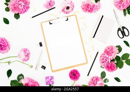 Luogo di lavoro piatto con portadocumenti, fiori rosa e accessori su sfondo bianco. Disposizione piatta, vista dall'alto. Foto Stock