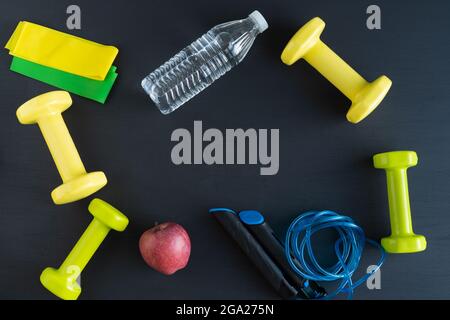 Attrezzature sportive su sfondo nero per esercitarsi a casa. Spazio di copia. Foto Stock