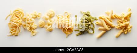 Vista dall'alto di vari tipi di pasta, spaghetti e tagliatelle isolati sullo sfondo chiaro Foto Stock