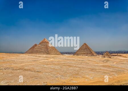 Una vista grandangolare delle 3 principali piramidi di Giza Egitto dal deserto che guarda indietro verso il Cairo. Foto Stock