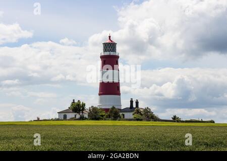 Faro rosso e bianco a Happisburgh sotto gli ampi cieli aperti del Nord Norfolk, preso il 5 luglio 2021. Foto Stock