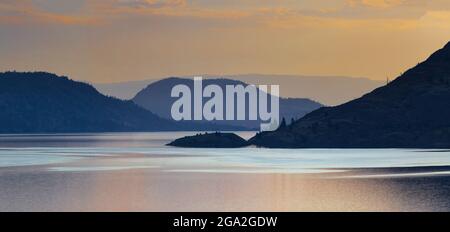 Tranquillo tramonto dorato sul lago Okanagan; British Columbia, Canada Foto Stock