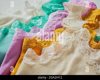 Pezzi colorati di abbigliamento con pizzo rifinire in un mucchio; Studio Foto Stock
