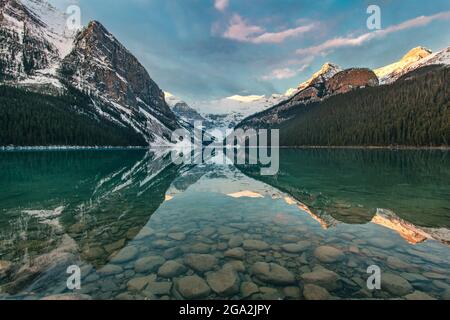 Lago Louise che riflette le Montagne Rocciose con neve in autunno, Banff National Park; Alberta, Canada Foto Stock