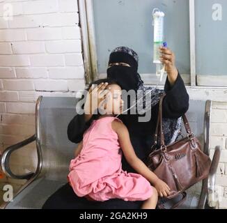 Dhaka, Bangladesh, 28 luglio 2021: Una persona tiene il suo bambino mentre attende che sua figlia sia frequentata all'ospedale dei bambini, perché è stata infettata da una nuova epidemia del virus della dengue. Credit: Habibur Rahman / Eyepix Group/Alamy Live News Foto Stock