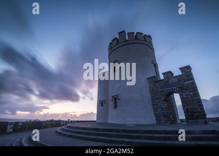 O'Brien's Tower con un cielo drammatico al tramonto che si affaccia sull'oceano lungo le scogliere di Moher sulla costa atlantica; County Clare, Irlanda Foto Stock