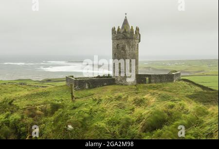 Doonagore Castello vicino al villaggio di Doolin si affaccia sul mare dell'Atlantico in una giornata di nebbia; Doolin, Contea di Clare, Irlanda Foto Stock