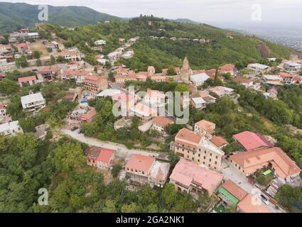 Veduta aerea della storica cittadina montagnosa di Signagi con i suoi tetti rossi in argilla che si affacciano sulle montagne del Caucaso maggiore nella Georgia orientale Foto Stock