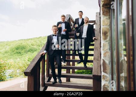 Lo sposo e i suoi amici celebrano il matrimonio. Uomini in abiti. Emozioni e amicizia degli Mens. Foto Stock