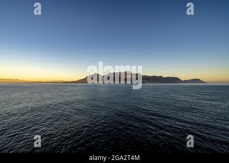 Vista spettacolare di Devil's Peak, Table Mountain e dello skyline di Città del Capo all'alba che sorge dal mare; Città del Capo, Provincia del Capo, Sud Africa Foto Stock