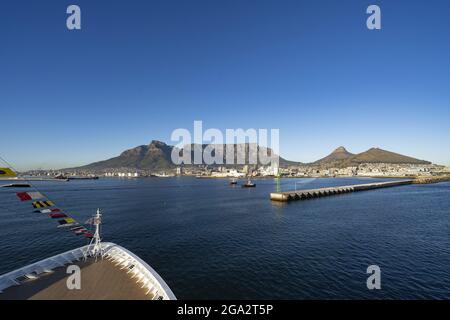 Primo piano dell'arco di una nave a Table Bay guardando verso il porto di Città del Capo e il maestoso Devil's Peak, Table Mountain e Lion's Head Risin... Foto Stock