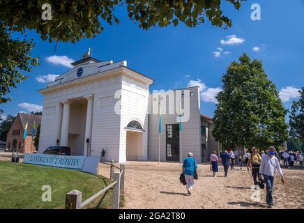 Redefin, Germania. 24 luglio 2021. Gli spettatori vanno nella sala di equitazione presso il prigioniero di stato. Qui si svolge il concerto con la Zurich Chamber Orchestra. Dopo una pausa forzata dovuta a corona lo scorso anno, i concerti del festival si svolgono nuovamente in base alle norme di protezione corona. Questo fine settimana, nella sala di equitazione della fattoria classica, si terranno quattro concerti in totale. Sono ammessi al massimo 1250 ascoltatori. Prima del concerto, c'era il tradizionale picnic all'aperto e uno spettacolo di cavalli da guardare. Credit: Jens Büttner/dpa-Zentralbild/ZB/dpa/Alamy Live News Foto Stock