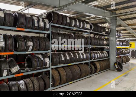 Tire Bay al circuito di Silverstone, Northamptonshire, Regno Unito. Rack di pneumatici per una vasta gamma di auto in pista. Foto Stock