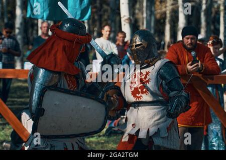 Due cavalieri in armatura imitano una lotta con la spada. Festa della cultura medievale nel Parco. Ricostruzioni di battaglie storiche. Bishkek, Kirghizistan - 13 ottobre 2019 Foto Stock