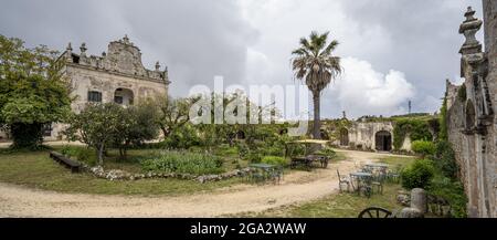 Nuvole grigie su una villa italiana e il giardino recintato nelle colline sopra Ostuni; Ostuni, Puglia, Italia Foto Stock