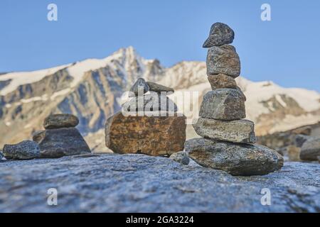 Cairns in piedi con il Monte Grossglockner sullo sfondo accanto a Gamsgrubenweg, Franz-Joseph-Hohe la mattina presto; Karnten, Austria Foto Stock