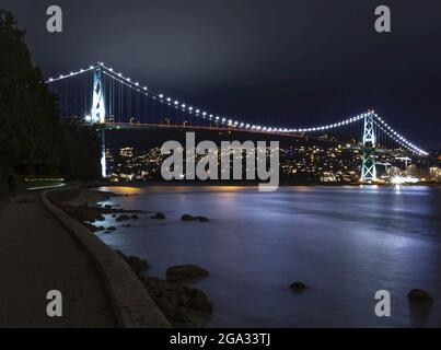 Ponte illuminato Lions Gate Bridge di notte visto dalla parete di mare in Stanley Park a Vancouver, BC; Vancouver, British Columbia, Canada Foto Stock
