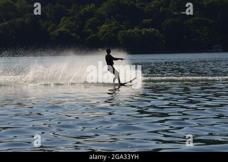 Sci d'acqua giovane al tramonto nella regione dei Finger Lakes; New York, Stati Uniti d'America Foto Stock