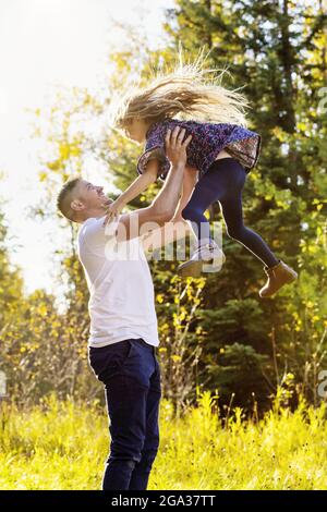 Un padre e sua figlia trascorrono del tempo insieme all'aria aperta in un parco cittadino durante la stagione autunnale; Edmonton, Alberta, Canada Foto Stock