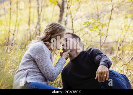 Una coppia matura sposata che trascorre del tempo insieme in un parco cittadino durante la stagione autunnale; St. Albert, Alberta, Canada Foto Stock