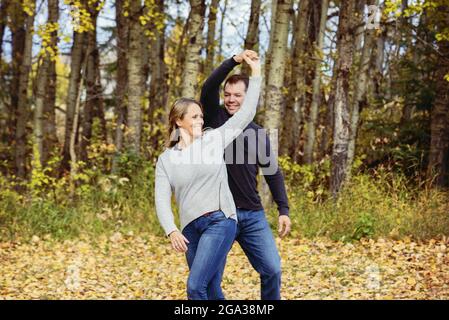 Una coppia sposata trascorre del tempo di qualità insieme e balla all'aperto in un parco cittadino durante la stagione autunnale; St. Albert, Alberta, Canada Foto Stock