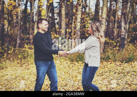 Una coppia sposata trascorre del tempo di qualità insieme e balla all'aperto in un parco cittadino durante la stagione autunnale; St. Albert, Alberta, Canada Foto Stock